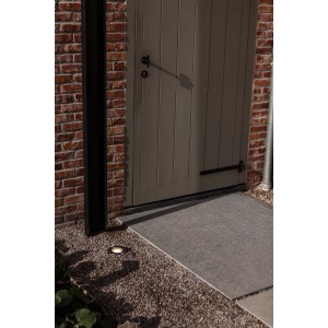 Lutec LED-Bodeneinbaustrahler Strata im Außenbereich vor einer Tür. Warmweißes Licht.