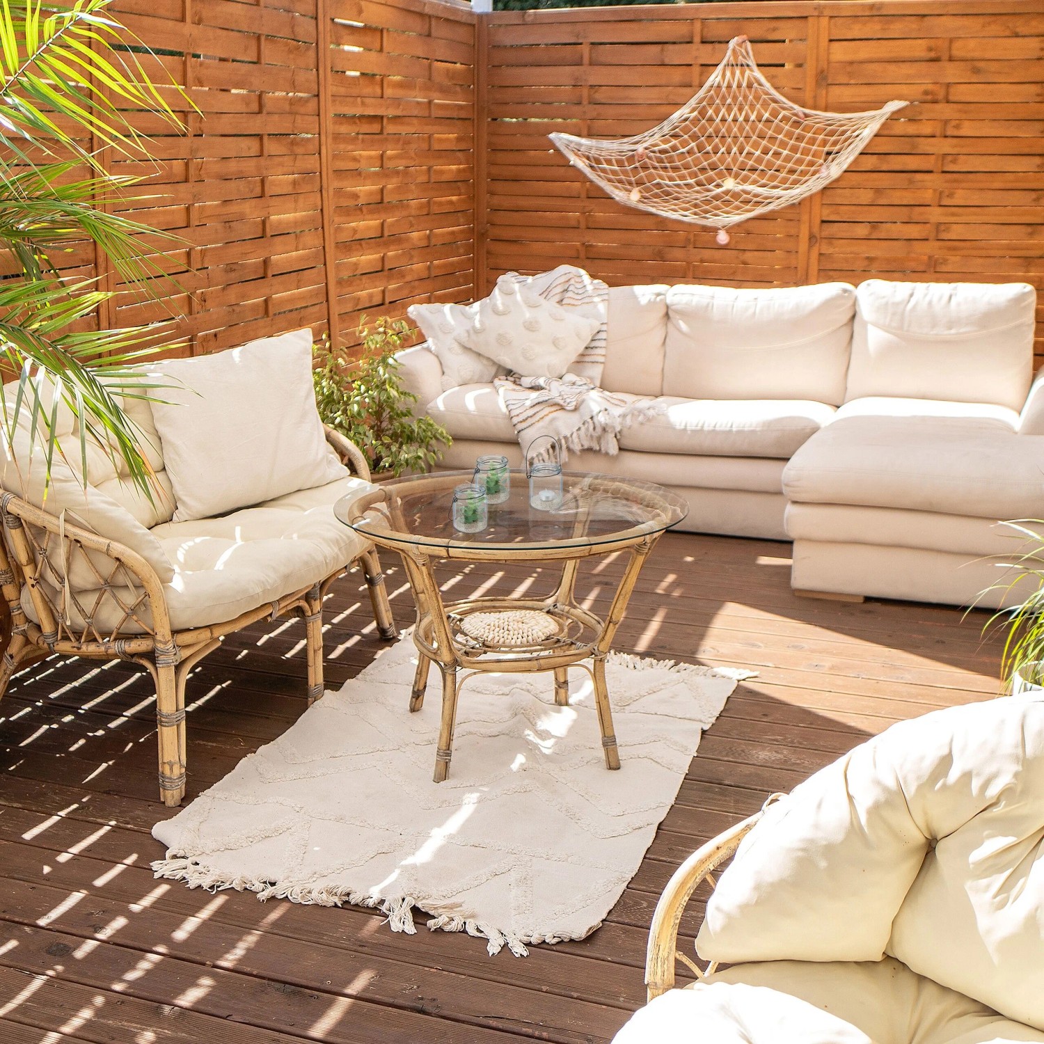 Transparente Glas-Windlichter mit schwarzem Henkel auf einem Gartentisch. Ideal für Teelichter und gemütliche Deko auf Balkon oder Terrasse.