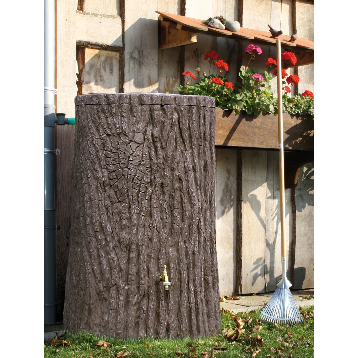 Dunkelbraune Arves Regentonne Evergreen 475 l in Baumstammoptik mit Auslaufhahn im Garten.