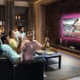 LEDVANCE Flex TV LED-Streifen als Stimmungslicht hinter einem Fernseher, mit feiernden Personen.
