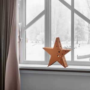 Rostfarbener Kobolo Deko Stern XL mit Sternenmuster als Teelichthalter auf Fensterbank.