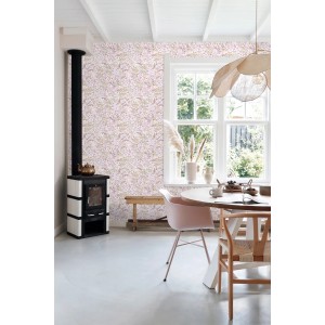 Wand mit ESTAhome Vliestapete Feldblumen in Violett und Graugrün in einem hellen Wohnraum mit Ofen und Tisch.