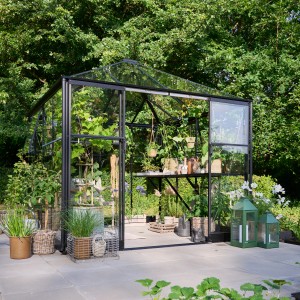 Schwarzes Halls Gewächshaus Qube Square mit Sicherheitsglas, bepflanzt und dekoriert im Garten.