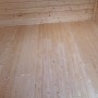 Innenansicht des grauen weka Holz-Gartenhauses Angolo B mit Holzboden und Holzwänden.