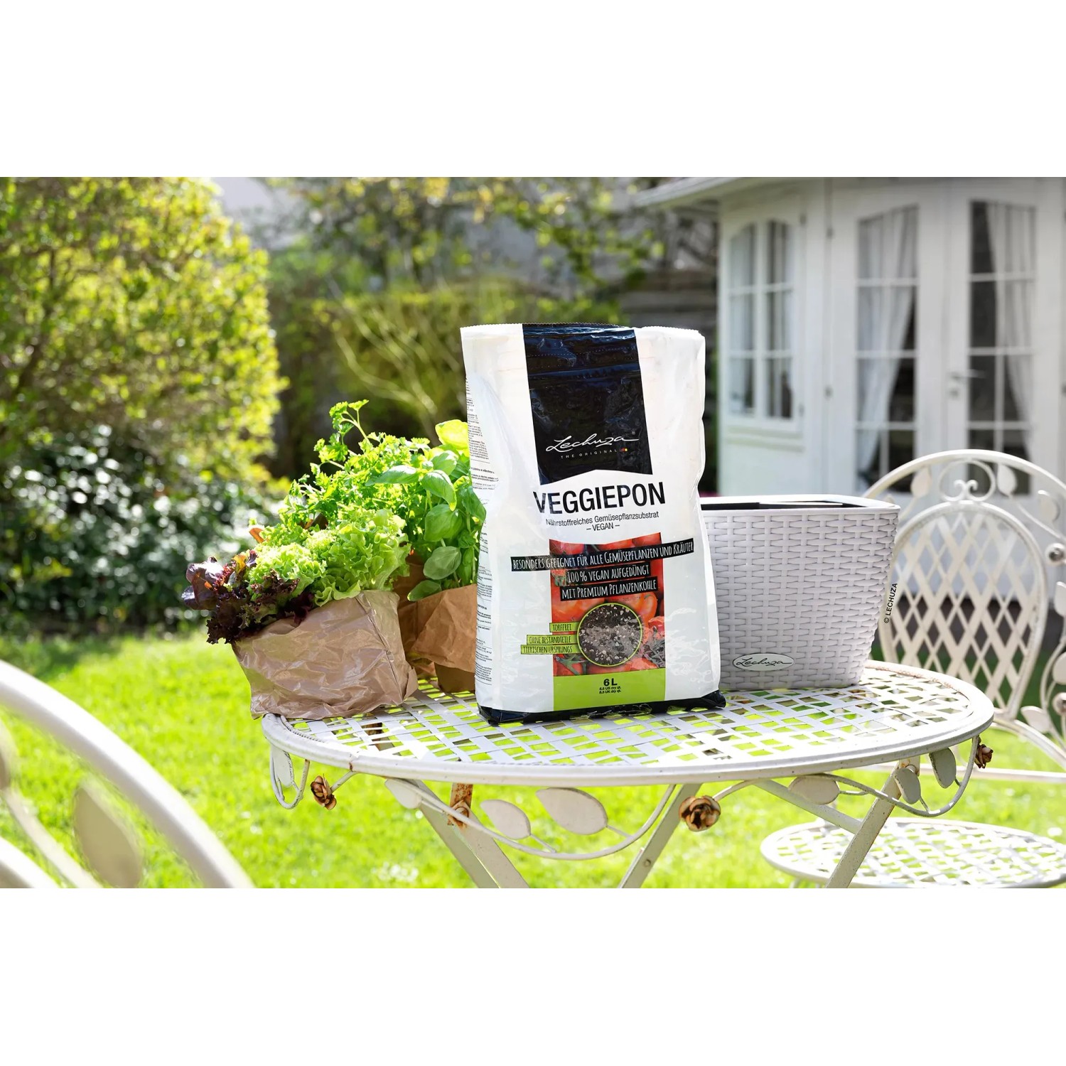 Lechuza Veggiepon Pflanzsubstrat 12L auf Gartentisch mit Gemüse und Kräutern.
