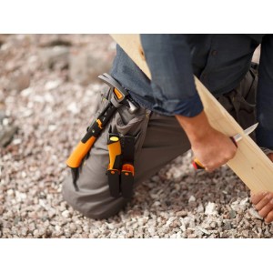 Fiskars Schreinermesser mit Schleifstein im Einsatz beim Bearbeiten eines Holzstücks.