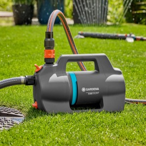 Gardena Gartenpumpe 5000 Silent Set auf Rasen mit angeschlossenem Schlauch.
