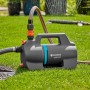 Gardena Gartenpumpe 5000 Silent Set auf Rasen mit angeschlossenem Schlauch.