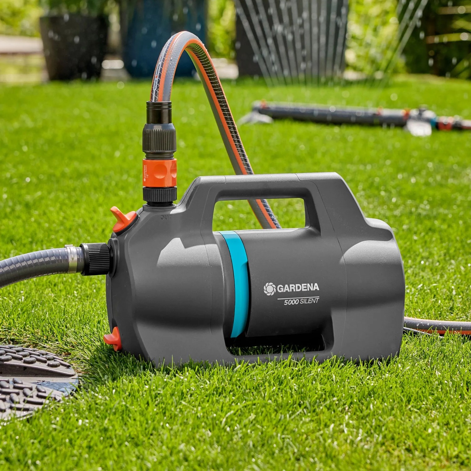 Gardena Gartenpumpe 5000 Silent Set auf Rasen mit angeschlossenem Schlauch.