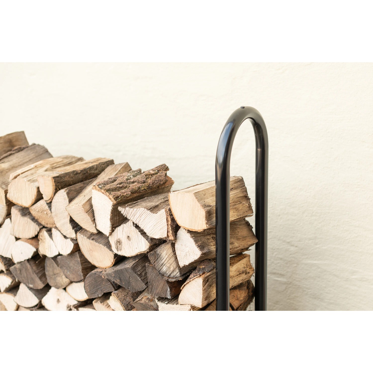 Schwarzes ShelterLogic Kaminholzregal (126x118cm) mit Holz gefüllt.