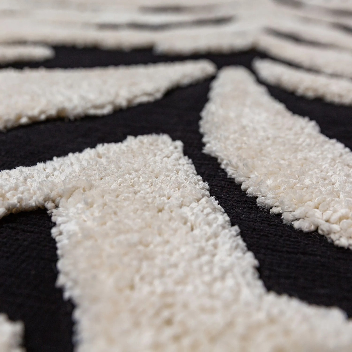 Nahaufnahme des Flair Rugs Hochflorteppichs Esra Zebra Schwarz-Weiß mit zotteligem Flor und Hoch-Tief-Struktur.
