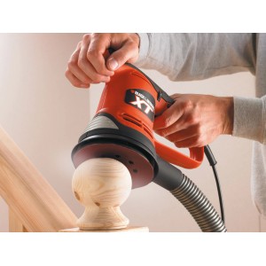 Black+Decker Exzenterschleifer KA191EK beim Schleifen eines Holzstücks.
