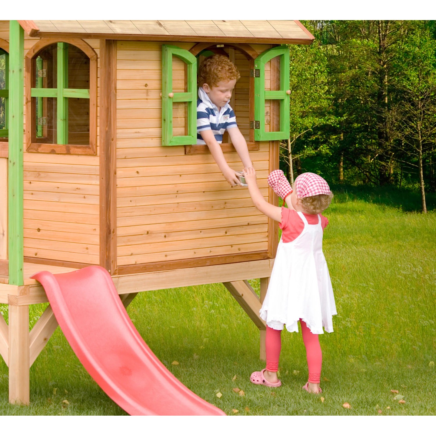 Axi Tom Spielhaus aus Holz mit roter Rutsche, Kinder spielen am Fenster.