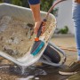 Gardena Cleansystem Handbürste M hard mit Schlauchanschluss beim Reinigen einer Schubkarre.
