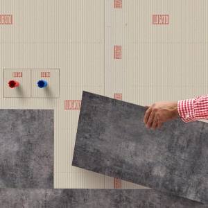 Verlegen von grauen Designbelägen mit Lugato Doppel Plus Klebstoff an einer Wand.