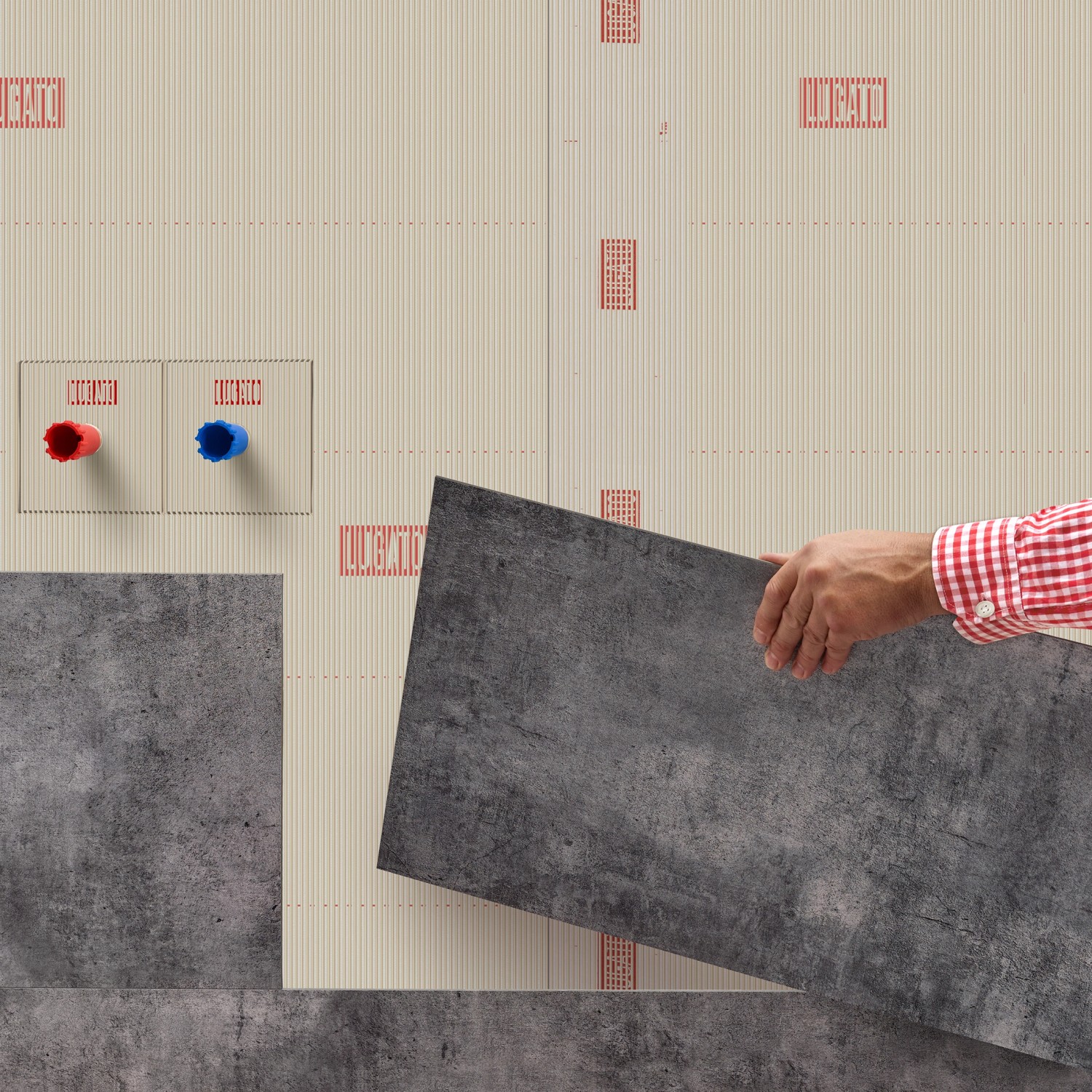 Verlegen von grauen Designbelägen mit Lugato Doppel Plus Klebstoff an einer Wand.