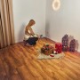 Frau montiert Ständer für künstlichen Weihnachtsbaum Nagano (150cm) mit Kunstschnee.