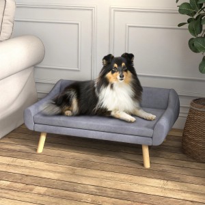 Hund liegt entspannt auf grauem PawHut Hundesofa mit Holzbeinen.