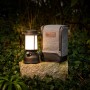 Petromax LED-Laterne PX-LM500 (schwarz) mit Tasche auf Stein im Grünen. Camping & Zubehör.