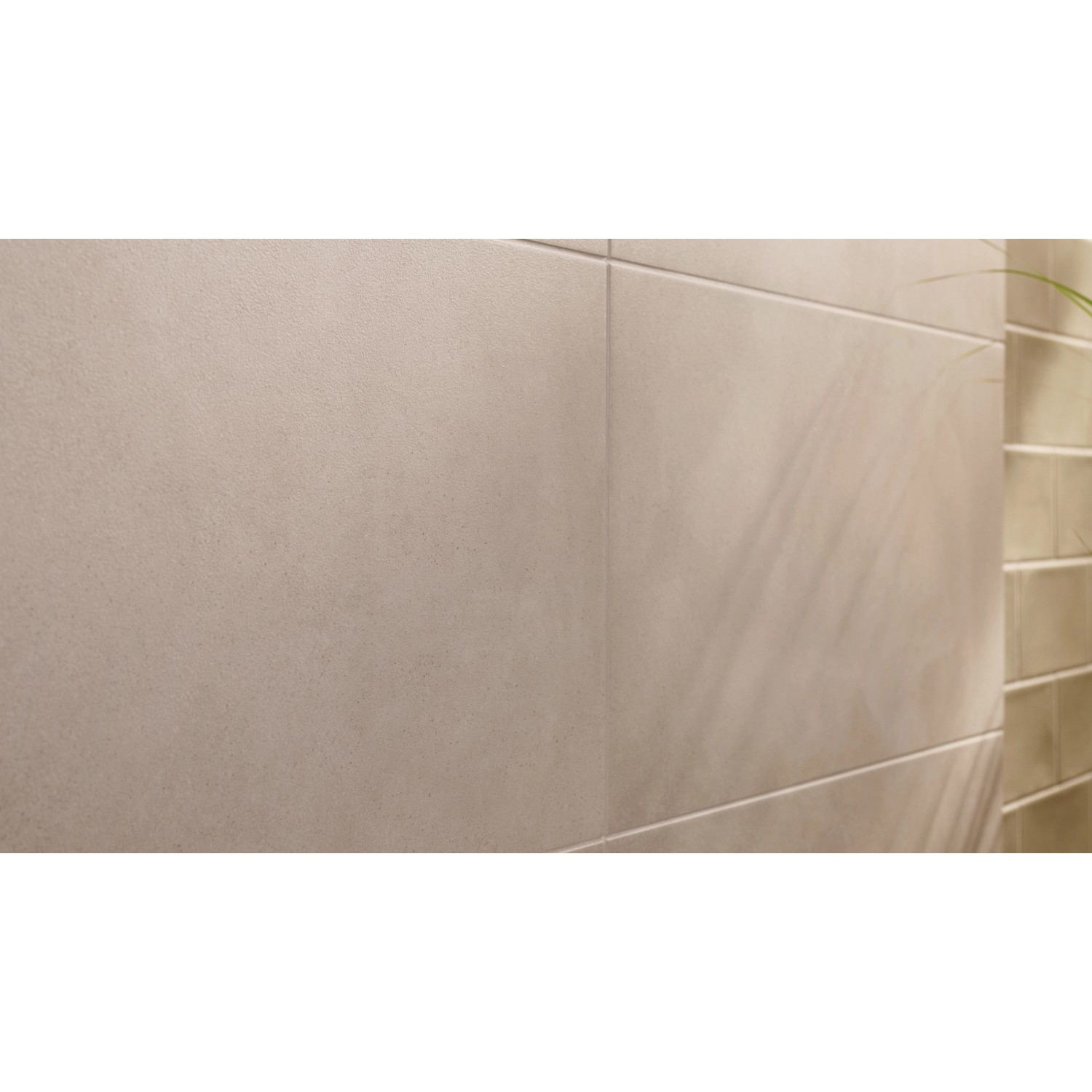 Nahaufnahme der Montagefläche für Tesa Handtuchhaken Moon Schwarz Matt auf beigen Fliesen.