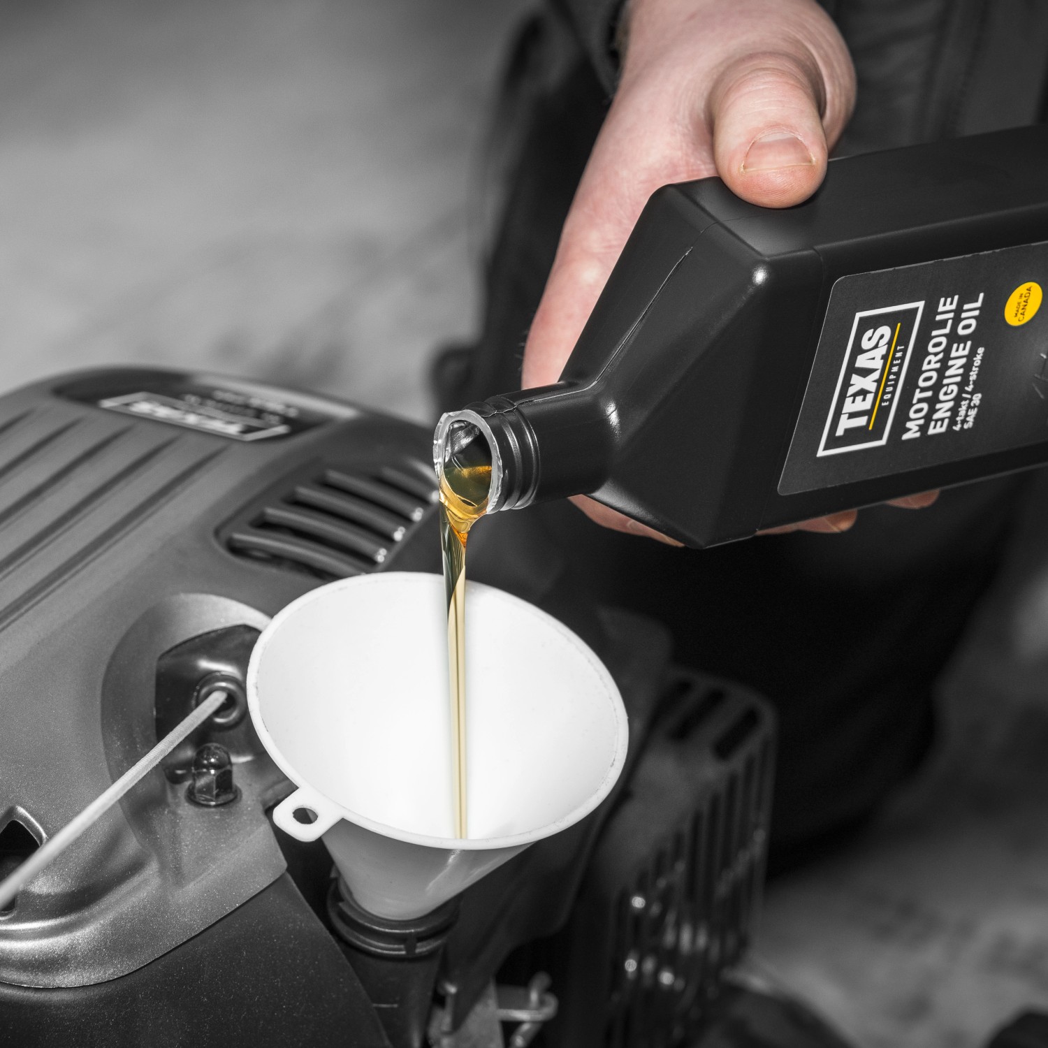 Texas Motoröl SAE30 0,6l wird in einen Rasenmäher eingefüllt.