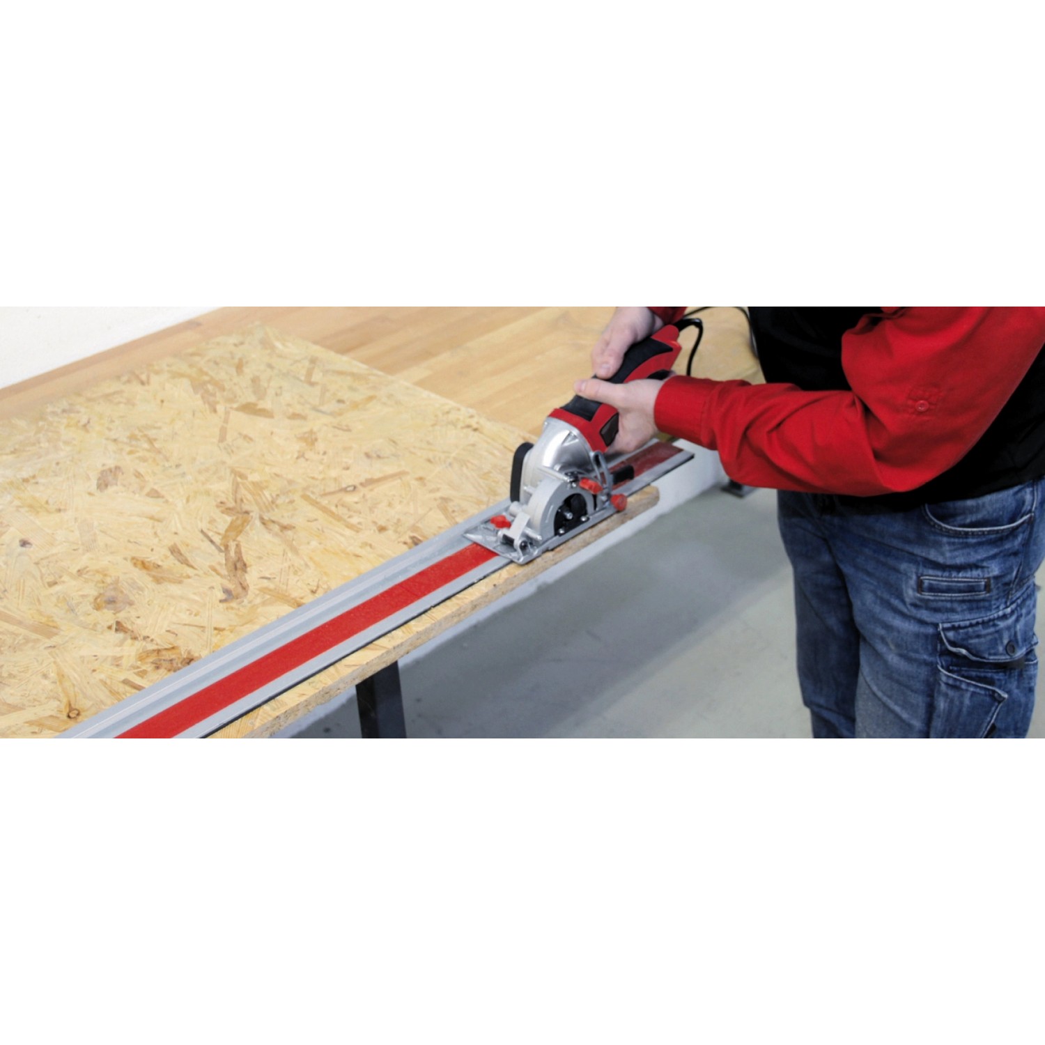 Einhell Mini-Kreissäge im Einsatz mit Führungsschiene auf Holzplatte.