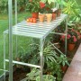 Alutisch mit einer Ablagefläche im Gewächshaus, bepflanzt mit Blumen und Gemüse.