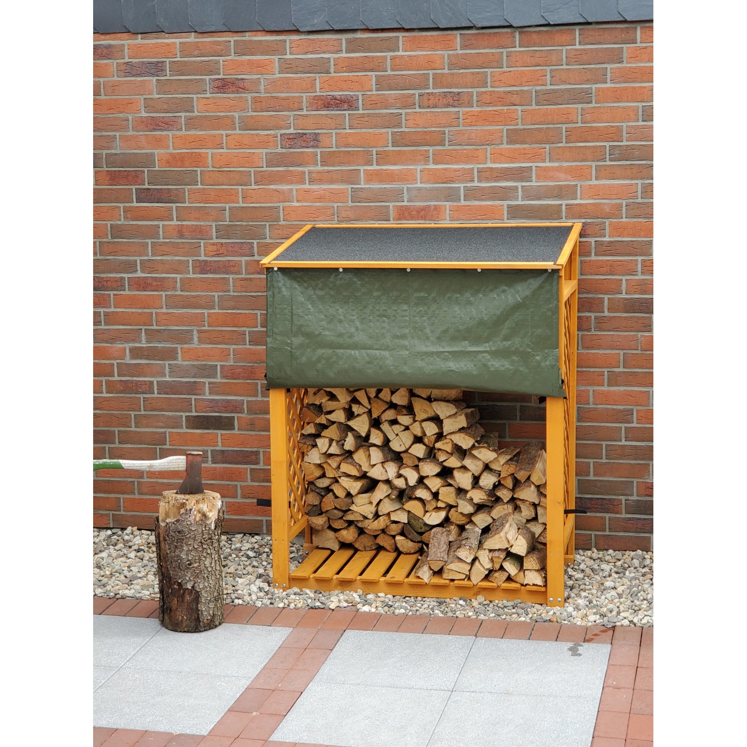 Honigbraunes Kaminholzregal Speyer mit Wetterschutz und Holzfüllung vor einer Ziegelwand.