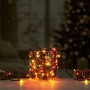 OBI Lichterkette Außen 400 Multicolor LEDs in Glasvase auf Holz, Tannenzapfen, festliche Stimmung.