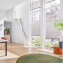 Intercon Raumspartreppe Alpha mit 11 weißen Buchenstufen und Polar-Weiß Metallgeländer. Moderne Innentreppe in hellem Raum.