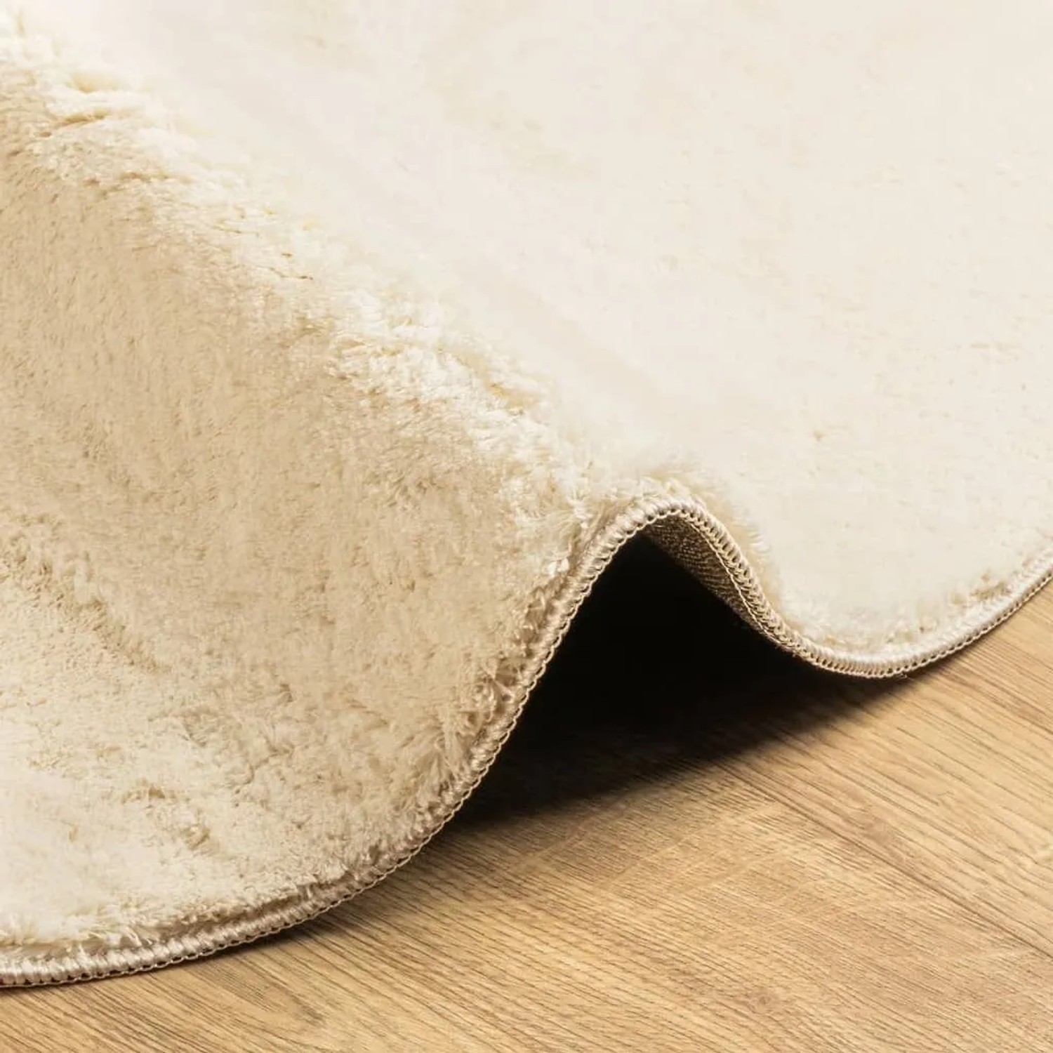 Weicher, cremefarbener Kurzflor-Teppich HUARTE auf Holzfußboden. Waschbarer Polyester-Teppich.