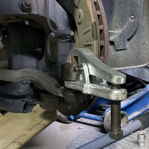 Kugelgelenkabzieher Set in Anwendung, trennt Spurstange am Fahrzeug. Robustes Werkzeug aus verzinktem Stahl für Autoreparatur.
