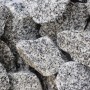 Nahaufnahme von Granitbruch Salz-Pfeffer, Körnung 80-200 mm, ideal für Garten- und Landschaftsbau.
