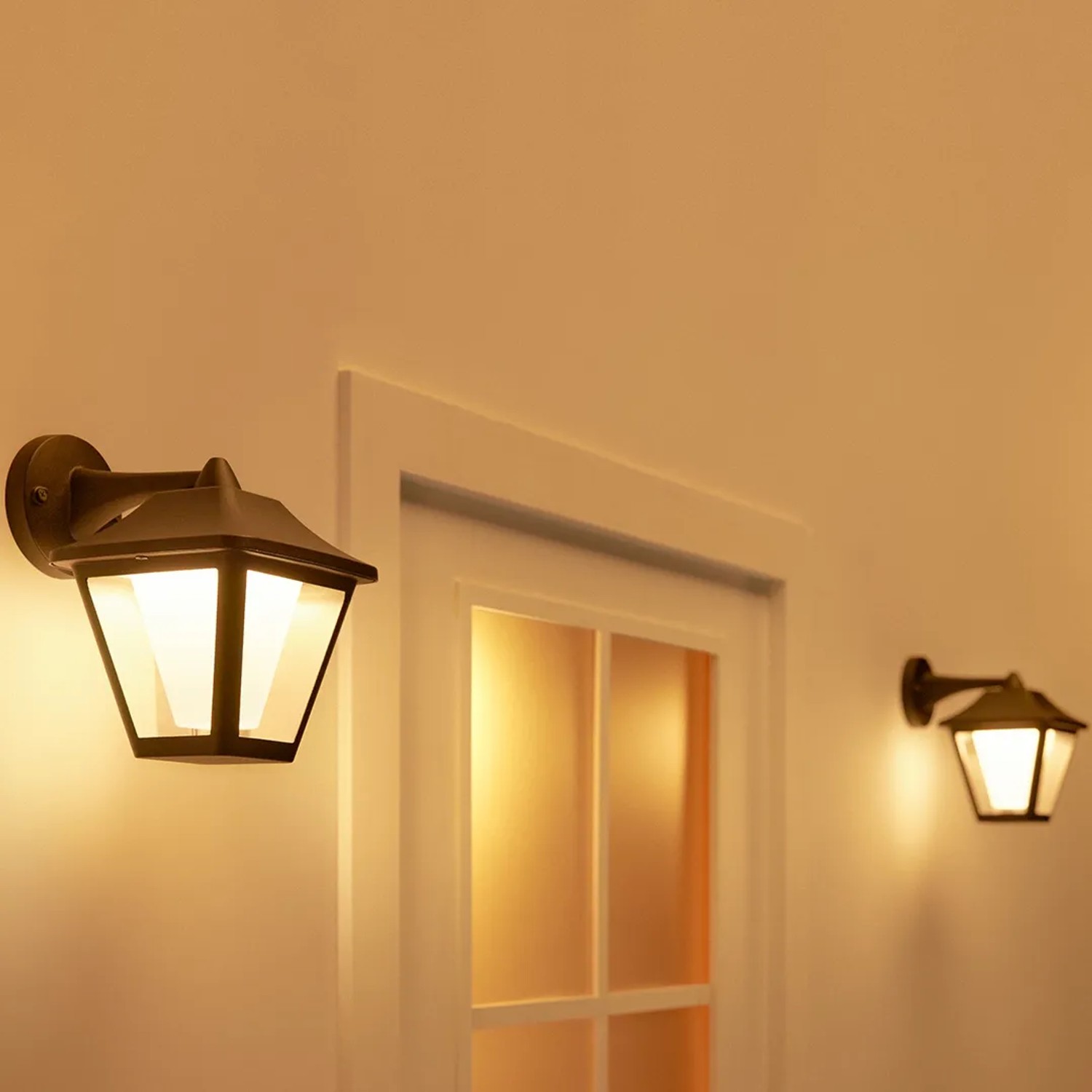 Schwarze WiZ Classic Außenwandleuchte mit warmweißem Licht an einer Hauswand.