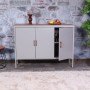 Graue MCW Kommode L84-3 mit drei Türen und Holzplatte im Wohnzimmer.