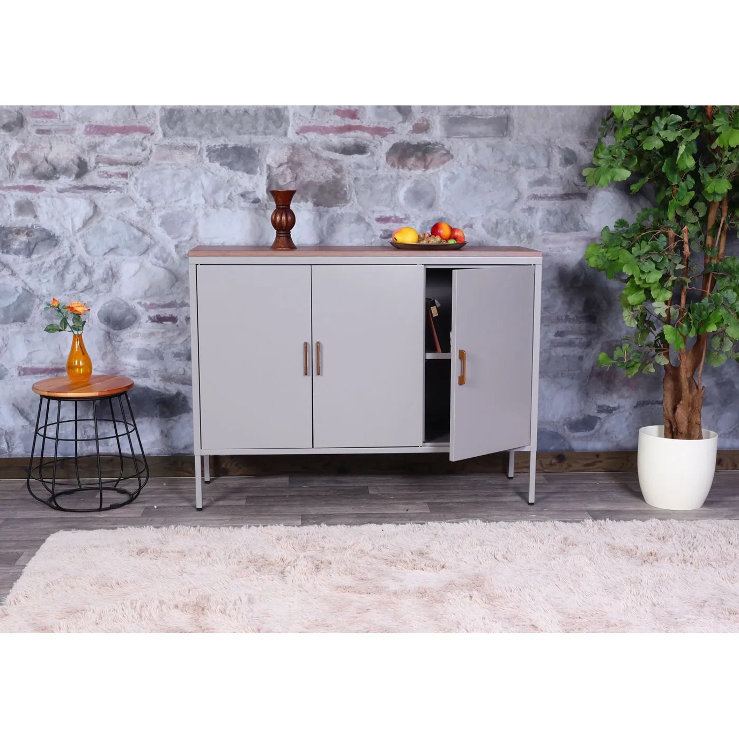 Graue MCW Kommode L84-3 mit drei Türen und Holzplatte im Wohnzimmer.