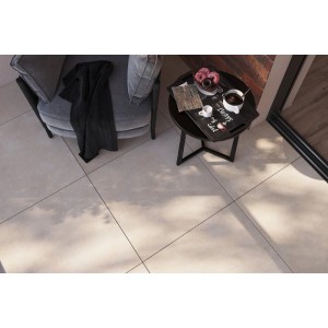 Beige matte Bodenfliesen 60x60 cm in Betonoptik, verlegt im Innenbereich mit Sitzgelegenheit.