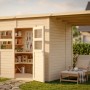 Helles Holz-Gartenhaus Felix2Plus mit geöffneter Tür und seitlichem Anbau im Garten.