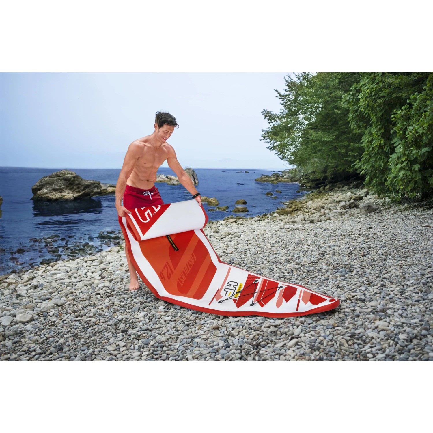 Bestway Hydro-Force SUP Fast Touring Board-Set, rot-weiß, mit Person am Strand.