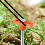 Oranger Felsbodenhering aus verzinktem Stahl mit schwarzem Abspannseil im Gras für Camping.