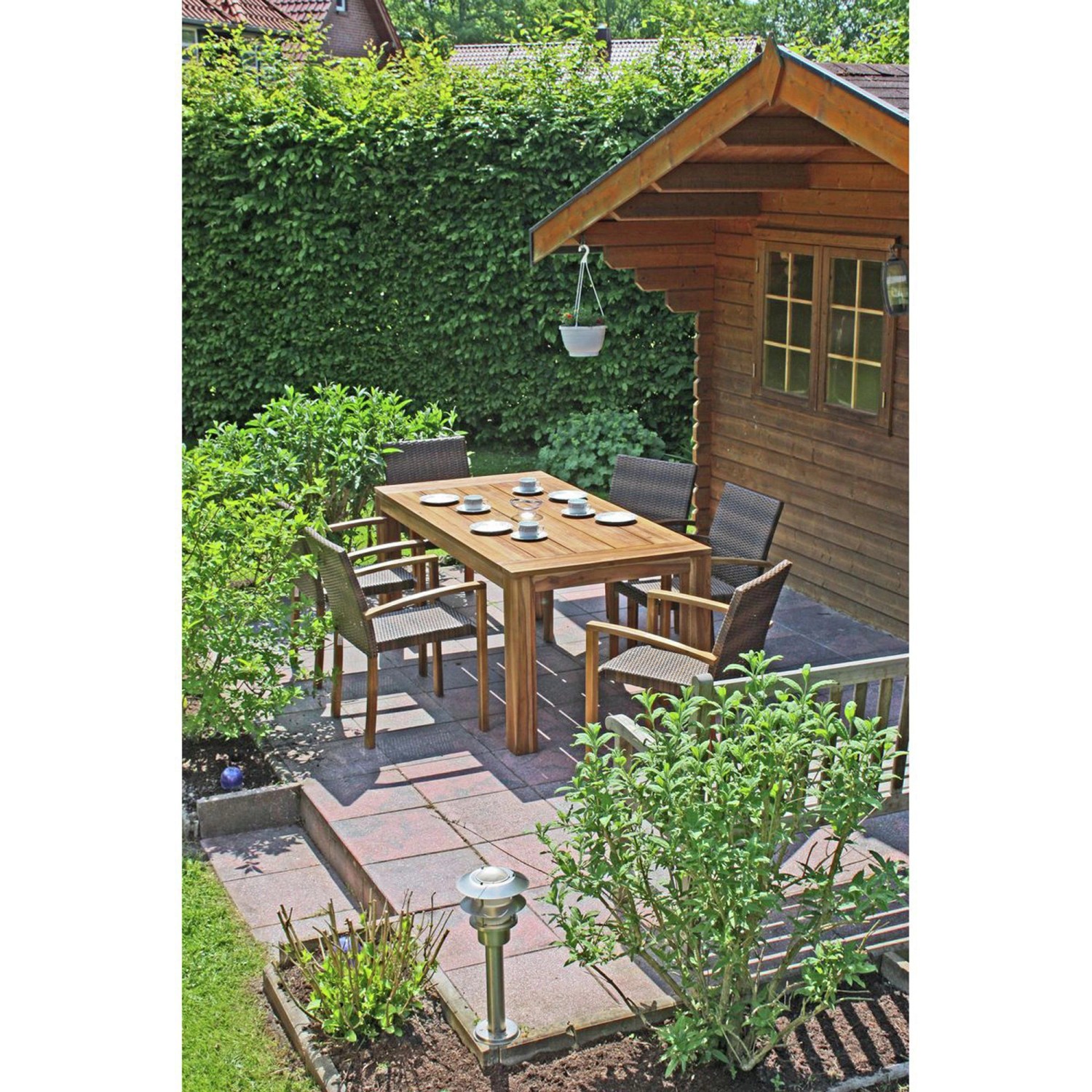Rechteckiger Garden Pleasure Gartentisch Topeka aus Holz mit Stühlen auf einer Terrasse.