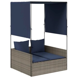 Graue Poly-Rattan Doppelliege mit blauem Dach, Vorhängen und Kissen. Komfortable Sonnenliege.