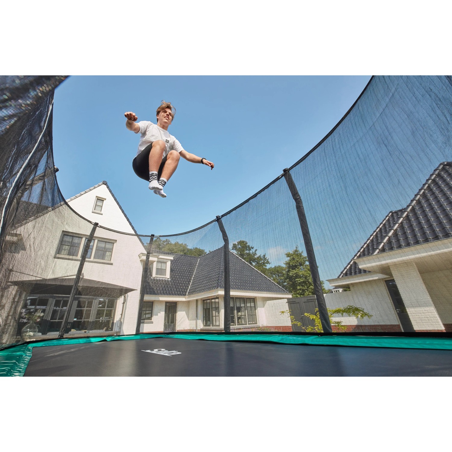 Grünes Salta Trampolin First Class 366x214 cm mit Sicherheitsnetz, Person springt.