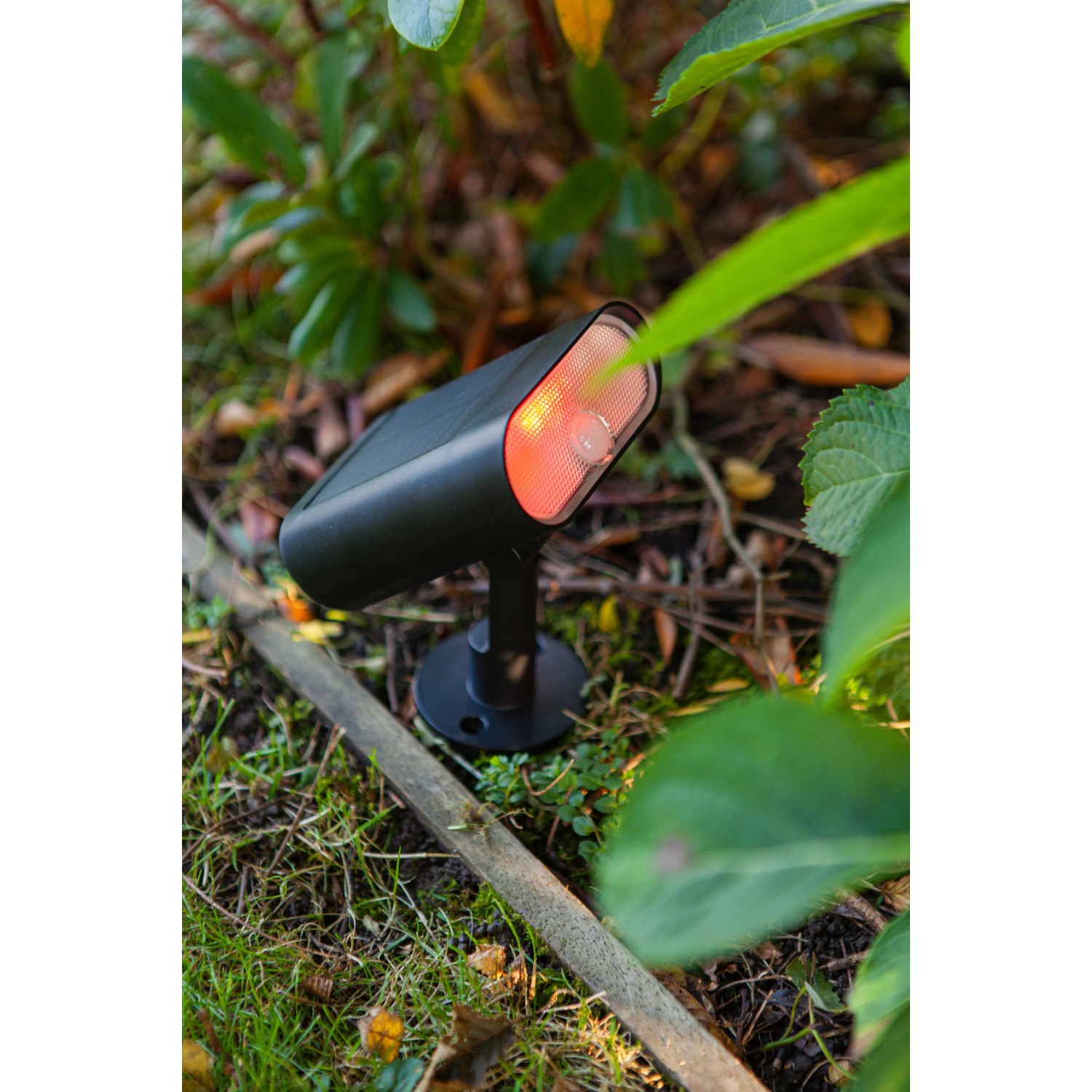 Schwarze Lutec LED Solar-Wegeleuchte Ginbo im Garten, warmweißes Licht.