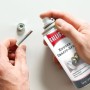 Hand sprüht Ballistol Kupfer-Grafit-Spray auf Schraube und Mutter. Schützt Gewinde vor Festfressen und Korrosion.