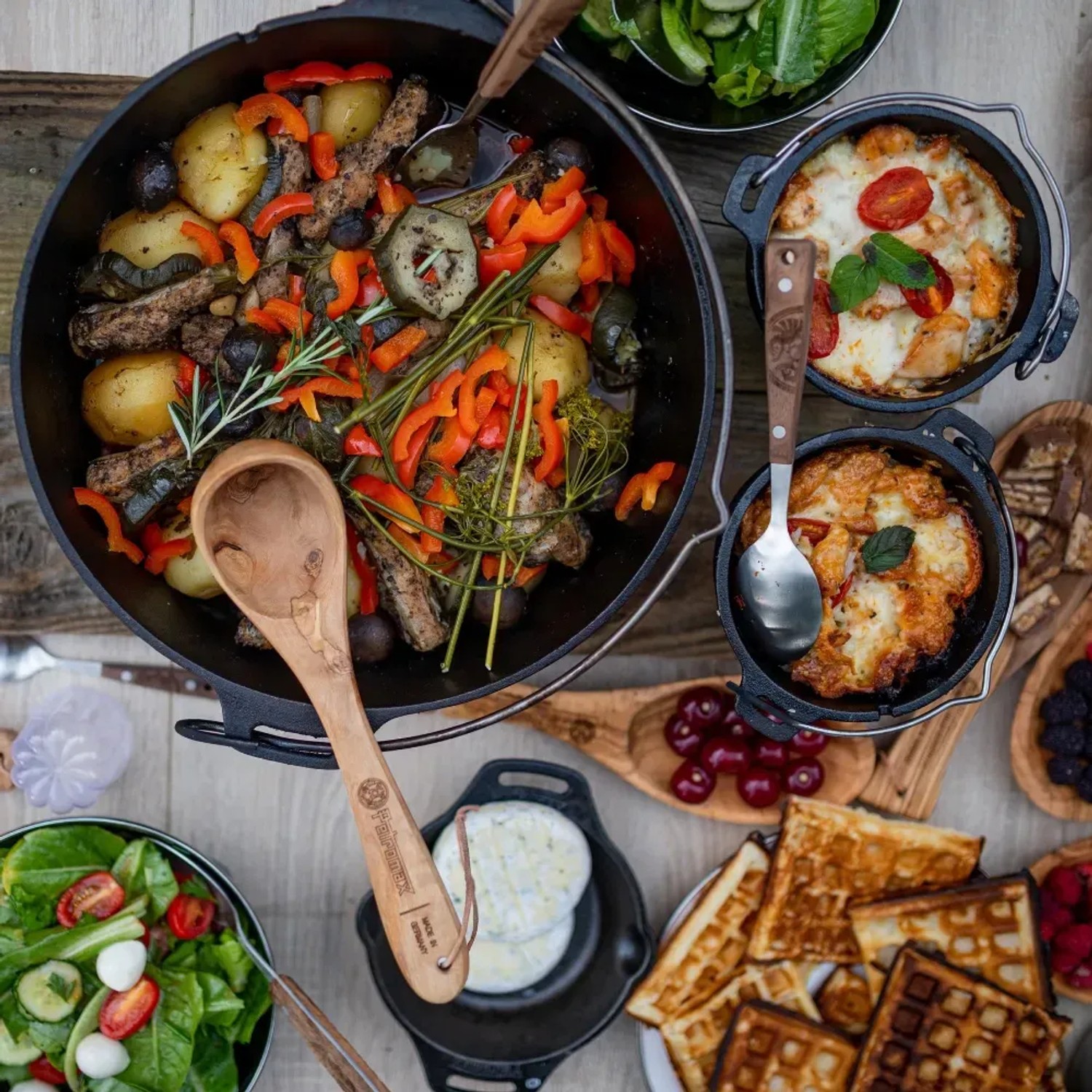 Petromax Dutch Oven FT12 mit Speisen, Salaten und Waffeln. Vielseitiges Kochgeschirr für Outdoor-Abenteuer.