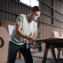 Mann mit Schutzbrille und Maske sägt Holz mit Bosch Professional Akku-Stichsäge GST 18 V-125 S.