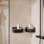 Schwarzer Tesa Lavaa Duschkorb Small an der Wand mit Duschutensilien.