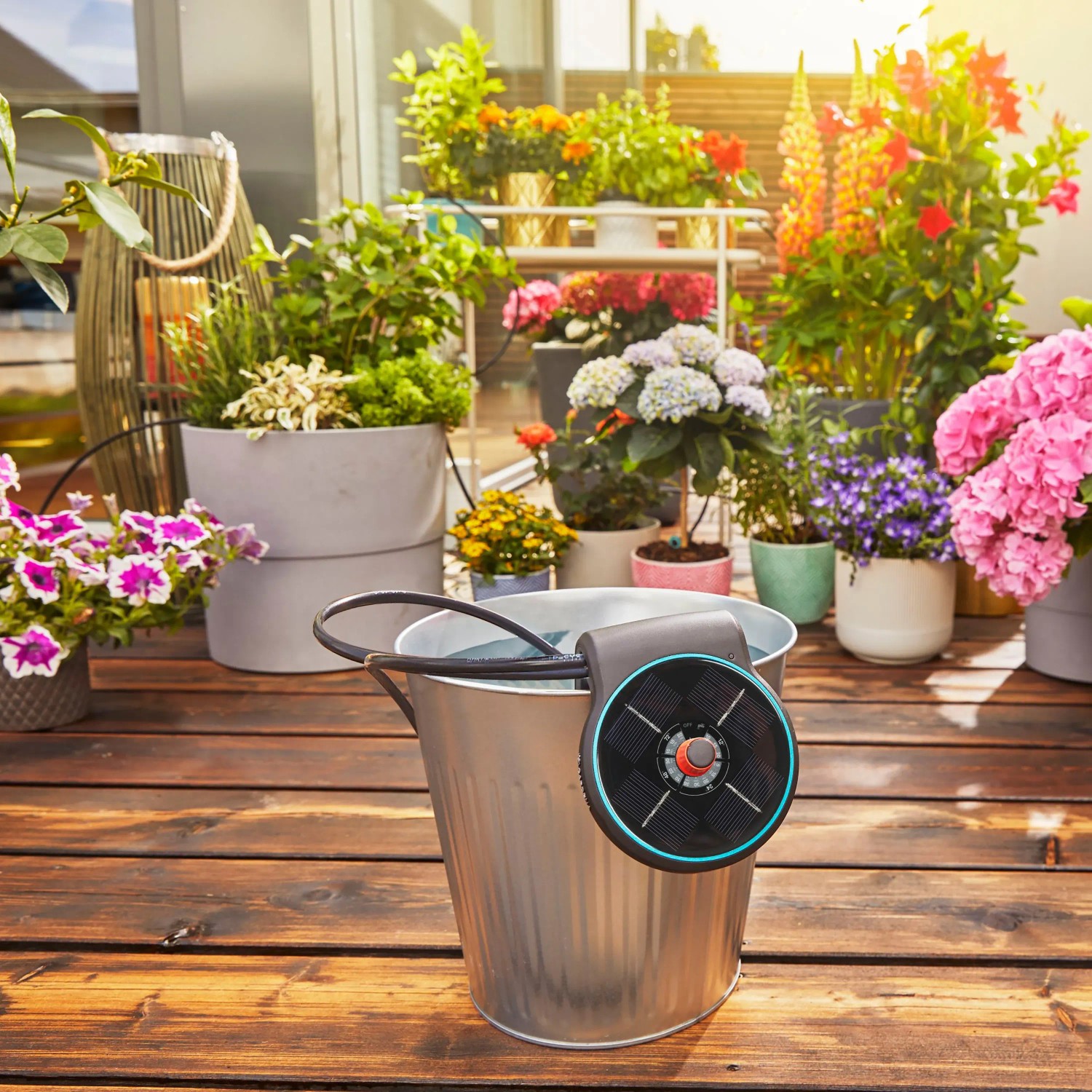Gardena Aqua Bloom Solar-Bewässerungsset im Eimer vor bepflanztem Balkon. Automatische Bewässerung.