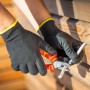 Hände mit LUX Arbeitshandschuhen Green Glove Gr. 8 schneiden Kabel mit einer Zange.